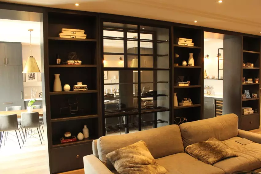 Custom black steel shelving and glass partition in a living room